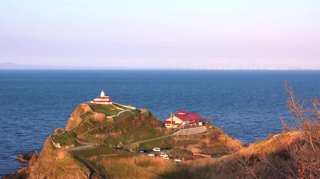 石狩湾と日和山灯台と小樽市鰊御殿の夕景