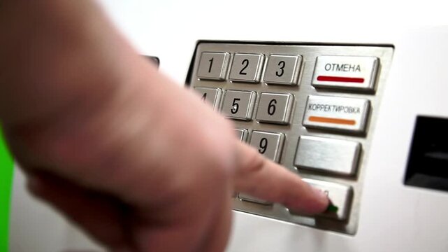 Human hand entering security pin code on ATM machine keypad for safe financial cash withdrawal transaction in 4K Ultra HD footage
