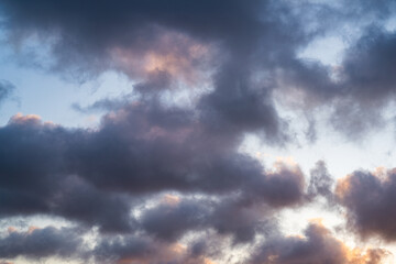 Fototapeta premium Dramatic evening sky with dark clouds and warm sunset light 