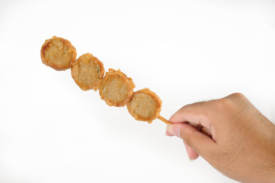 Hand holding fried fish balls