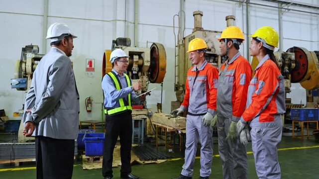 Group of engineers working together in an industrial environment wearing safety gear and using specialized equipment