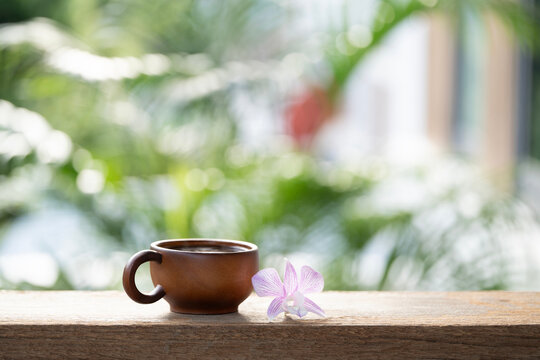 Wooden cup and purple orchid flower on wooden table