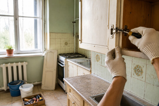 Trabajo en la cocina para arreglar un mueble con herramientas en un d&iacute;a soleado