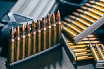 Rifle ammunition bullets on stripper clips with weapon background. Real photograph, not AI-generated © TimeStopper