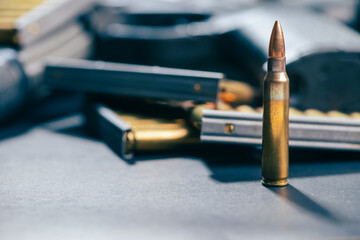 Rifle ammunition bullets on stripper clips with weapon background. Real photograph, not AI-generated © TimeStopper