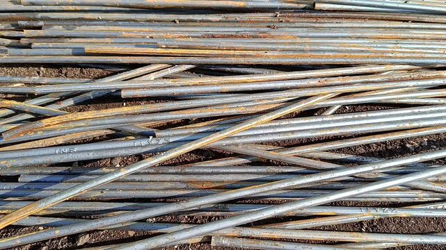 Handheld footage moving along stacked reinforcing steel bars