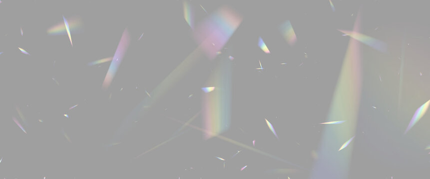 Scattered translucent fragments reflecting multicolored light beams against a dark background on transparent background
