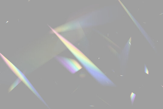 Illuminated sharp triangular prisms scattering rainbow light beams on black background on transparent background
