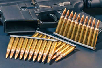Rifle ammunition bullets on stripper clips with weapon background. Real photograph, not AI-generated © TimeStopper