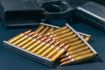 Rifle ammunition bullets on stripper clips with weapon background. Real photograph, not AI-generated © TimeStopper