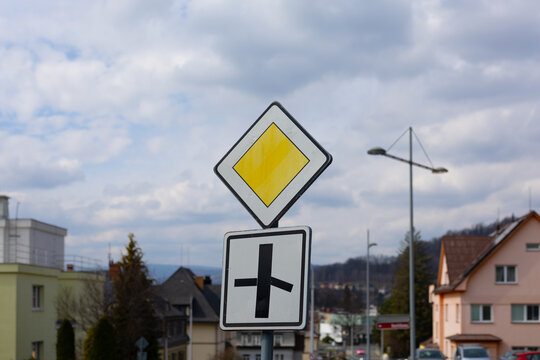 Traffic signs indicate a priority road at an intersection