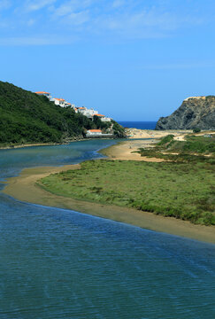 Portugal, Odeceixe. South-West Alentejo and Vicentine Coast Natural Park. View of the river estuary, cliffs  and village of Odeceixe beach. A growing tourist destination.