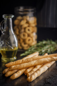 Golden Breadsticks With Olive Oil and Rosemary on Dark Table for Rustic Italian Snack