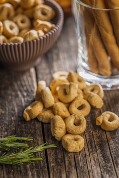 Rustic Italian Taralli Snacks and Grissini Breadsticks on Wooden Table with Fresh Rosemary