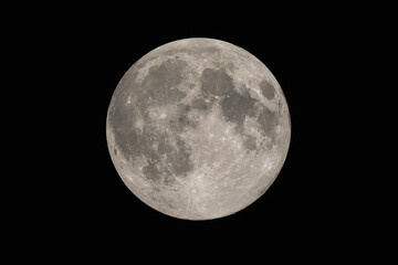 Fototapeta premium A full moon is visible against a black night sky.