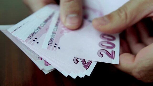 Close up of hand counting Turkish lira money banknotes for financial business transaction and economy budget in 4K Ultra HD footage
