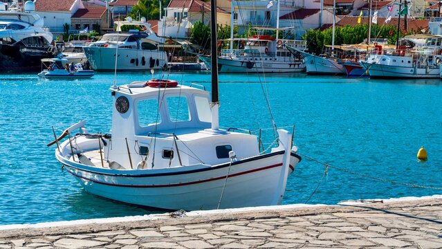 Pythagoreio, Greece - August 1, 2026: View of a small boat in the harbor of Pythagoreio on Samos Island, showing calm Aegean water, moored vessel, waterfront scenery, and coastal buildings 
