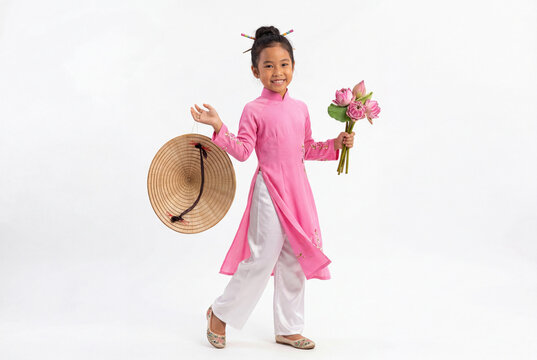 Young girl in pink ao dai holding lotus flowers and conical hat cultural heritage celebration