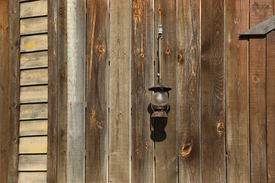 Vintage rusty lantern hanging on a rustic wooden wall