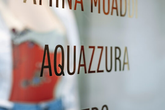 Nice, France - July 27, 2026: Close-up of a Galeries Lafayette window listing designer brands including Aquazzura, Amina Muaddi and Etro