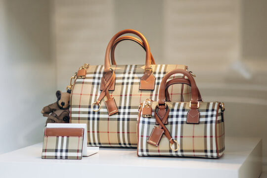 Nice, France - July 27, 2026: Burberry check handbags, cardholder and teddy bear charm displayed in a Galeries Lafayette window