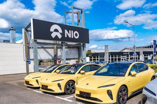 modern Silver yellow NIO electric cars parked large black NIO sign car dealership, premium Chinese automotive showroom exterior, car sales, dealership branding and marketing, Stuttgart, GERMANY