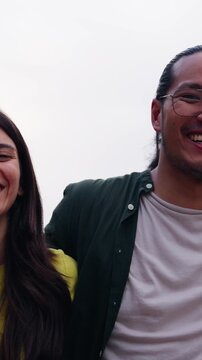 Vertical selfie of group young multi-ethnic beautiful friends having fun together outdoors. Excited people looking at happy camera enjoying sightseeing in city on sunny day. Generation z and vacations