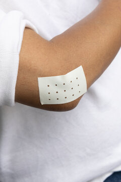 elbow closeup of asian senior man with tennis elbow and pain relieving patch on the arm, injury treatment concept, high angle view