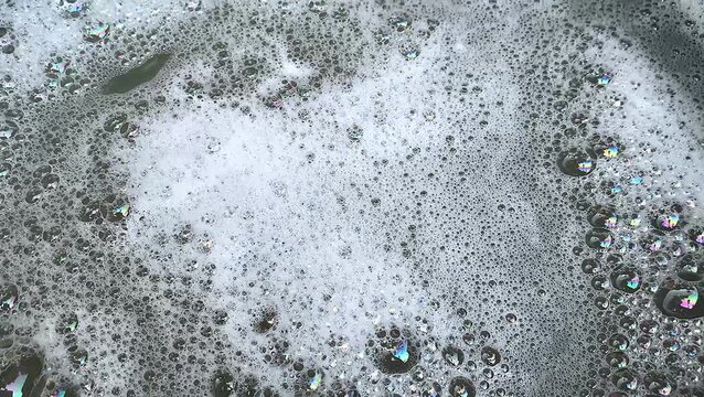 Foamy soap bubbles and water wave ripple texture motion background. flow splash.