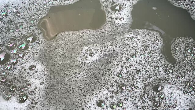 Foamy soap bubbles and water wave ripple texture motion background. shimmering bubbles.