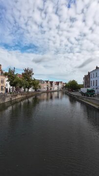 Static view over tranquil canal in historic center of Bruges, Belgium, vertical video