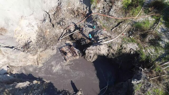 Manual Tin Mining Process with Diesel-Powered Water Spraying System