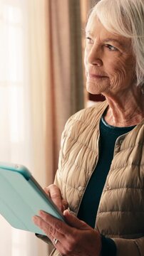 Senior, woman and thinking with tablet in home for ebook insight, web novel and download choice. Digital library, old person and tech at window for chapter release or subscription option for sign up