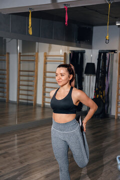 Athletic woman holding leg stretch with relaxed expression. Female athlete maintaining flexibility after fitness training concept.