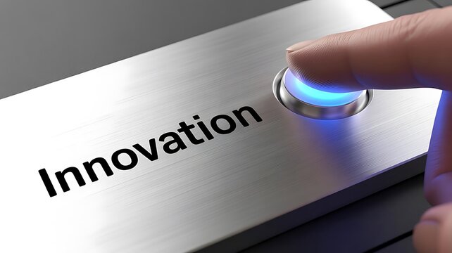 Close up of a human finger activating a brushed metal button with the word innovation printed below and a glowing blue light indicating success