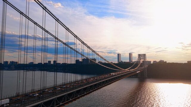 Rising over the George Washington Bridge with lively traffic of multiple cars. 