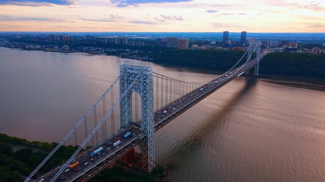 View on the Hudson River and beautiful double-decked suspension bridge. Numerous cars move by the George Washington Bridge in New York City, USA.