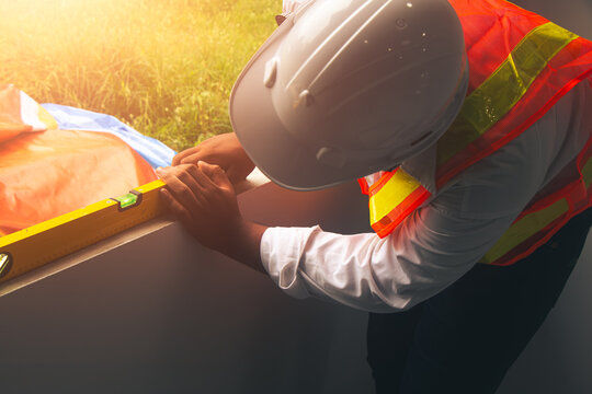 Construction engineers inspecting a modern house project using leveling tools to ensure structural accuracy.
