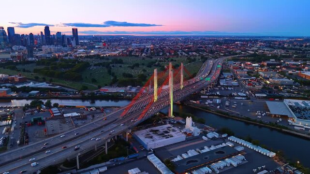 Multiple cars go by the Kosciuszko Bridge at sunset. Footage over New York City, USA near Newtown Creek.