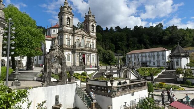 Scenic view of historic church and gardens in Braga Portugal, showcasing lush greenery, ornate architecture, and a funicular railway in a picturesque landscape under a bright blue sky