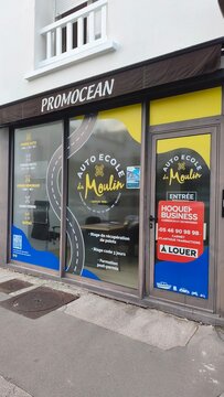 Royan, France - July 15, 2026: Charente-Maritime. Nouvelle-Aquitaine. Auto Ecole La Moulin driving school storefront with promotional signage and contact information in urban setting
