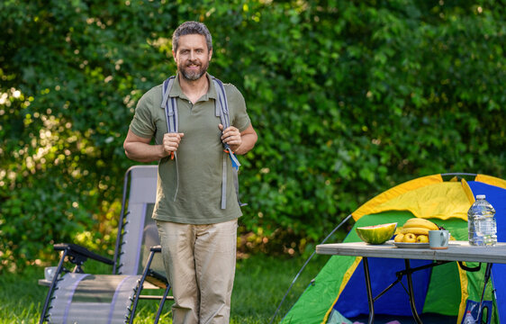 Summer camping retreat. Camp adventure. Hiking lifestyle. Man at campsite. Picnic time. Man at camp picnic in forest. Man hiking on summer day. Summer camp activity advertisement