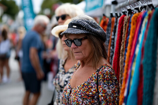 Scenic and perfectly framed perspective of artisan clothing market showcasing heritage garments made from natural fibers, shoppers appreciating traditional craftsmanship, clean outdoor setting
