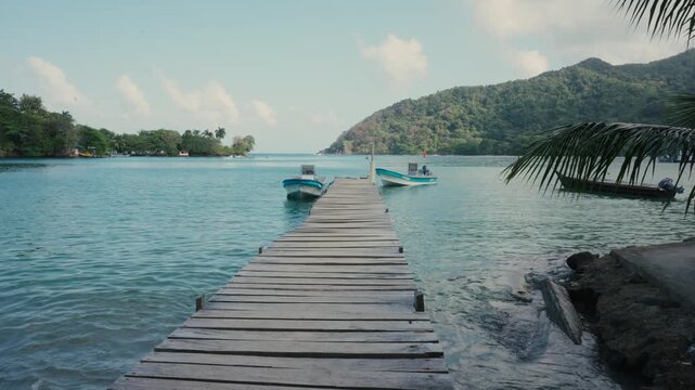 Wooden jetty and fishing boats on the turquoise sea, Sapzurro tropical bay, Colombia