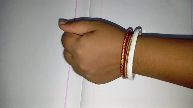 A hand wearing red and white bangles showing different gestures on paper like thumbs up