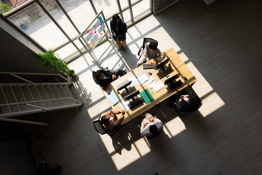 Top view. Company Operations Manager Meeting training and coaching Presentation. Diverse Team Uses with infographics Growth Analysis, Charts, Statistics and Data. People Work in Business Office