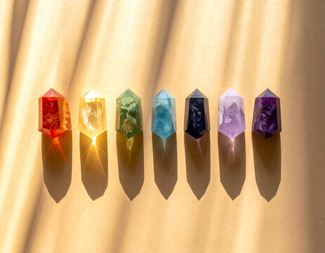Small crystals in red, orange, yellow, green, blue, and purple tones arranged neatly on a yellow background. Ai