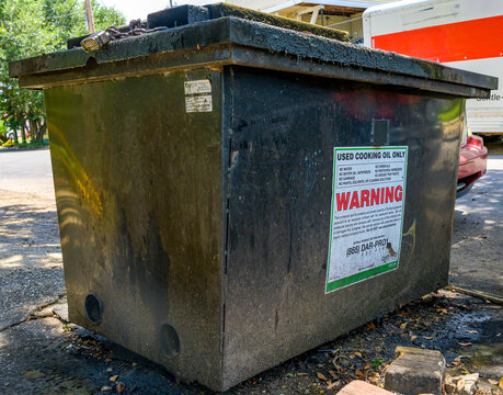 New Orleans, LA, USA - July 6, 2026: Closeup of Locked Steel Grease Trap Serviced by Dar Pro Solutions Company, Next to a Street Outside of an Uptown Restaurant