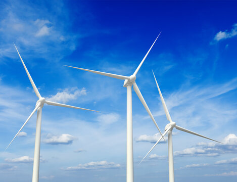 Green renewable energy concept - wind generator turbines against the sky