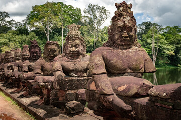 Fototapeta premium Ancient stone guardian statues lining the causeway at the South Gate of Angkor Thom in Siem Reap, Cambodia
